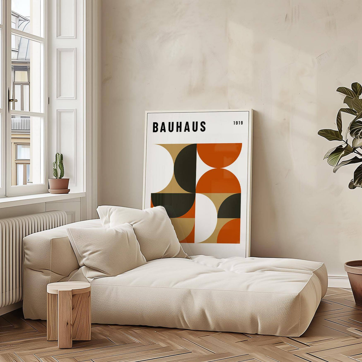 Office wall decor leaning on floor with beige, orange and black geometric shapes in a bright room near sofa and plant