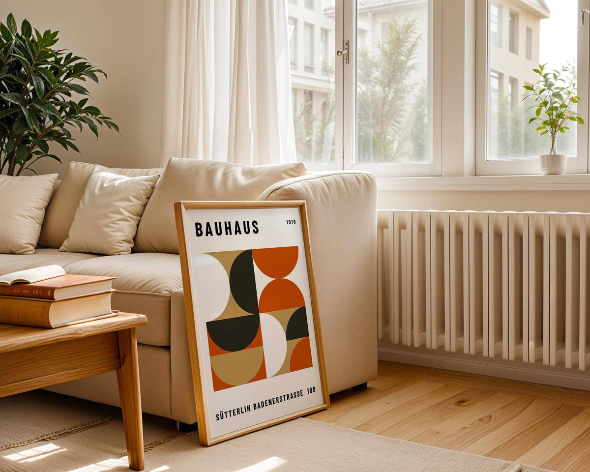 Office wall decor leaning on a beige sofa with books on a wooden table nearby