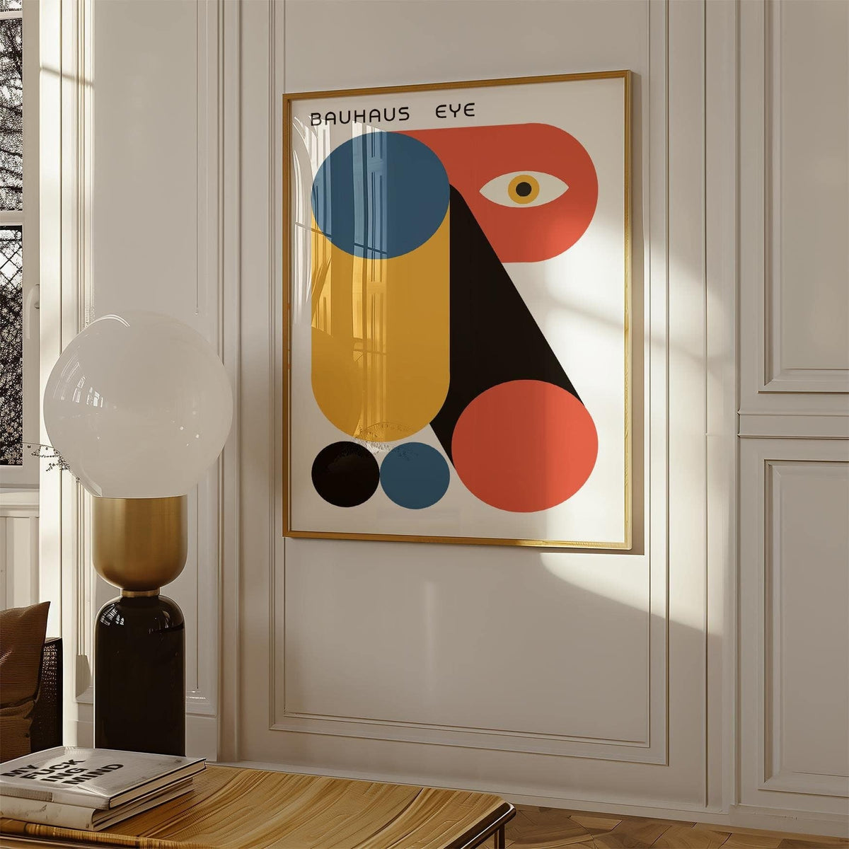 Framed Bauhaus Graphic print with abstract geometric shapes in muted red, blue and ochre on a white wall near a modern lamp