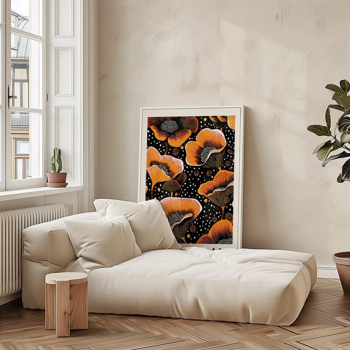 Orange print leaning on a beige sofa with stylised orange flowers on black background