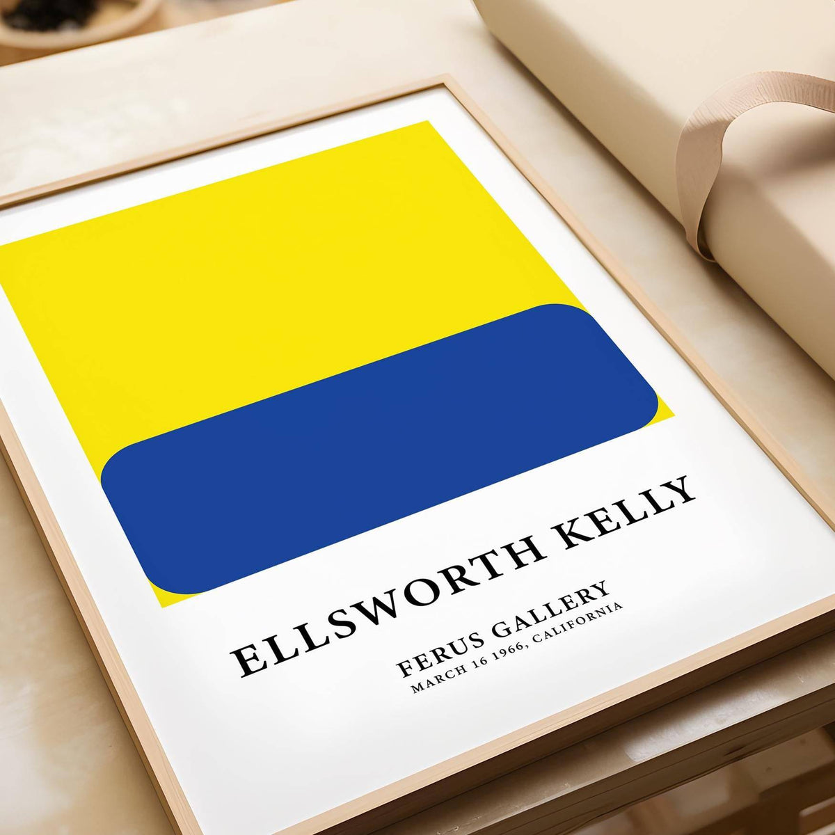 Minimalist artwork close-up showing a blue rounded rectangle on a yellow square with text under the image