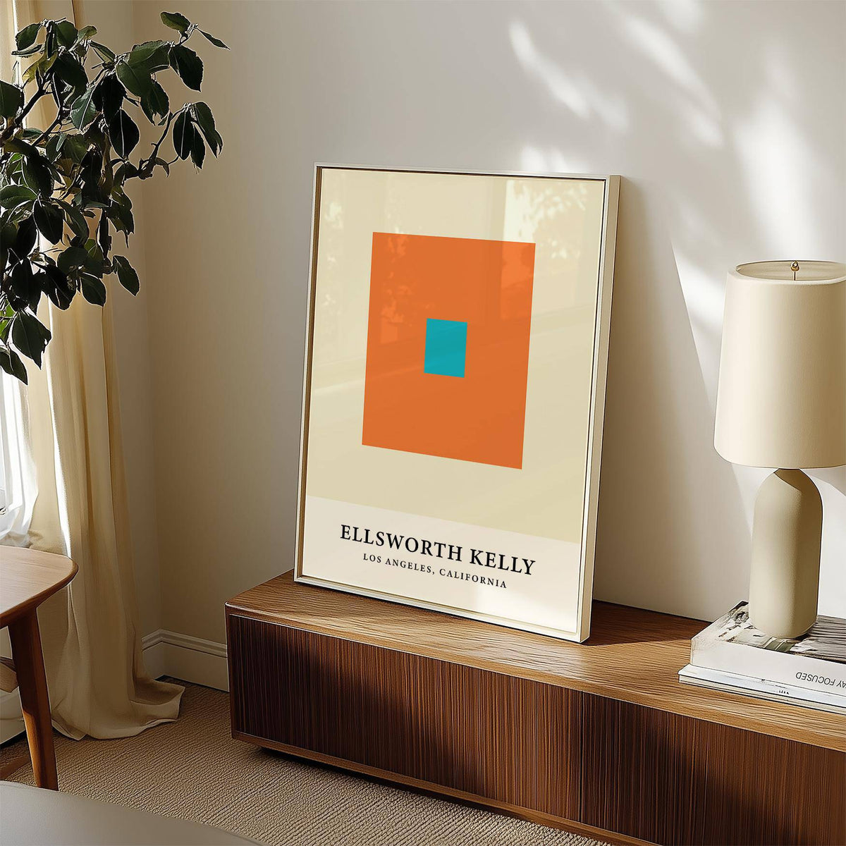Framed Ellsworth Kelly Artwork with orange and blue squares on a wooden sideboard beside a lamp