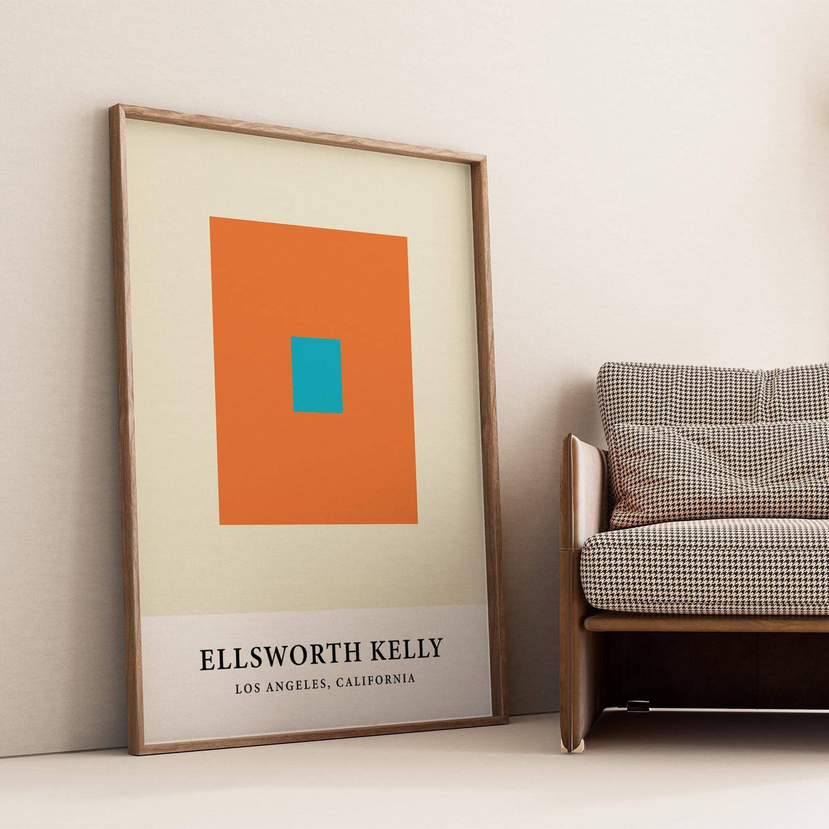 Print leaning on the floor with Ellsworth Kelly artwork of orange and blue squares near a patterned sofa