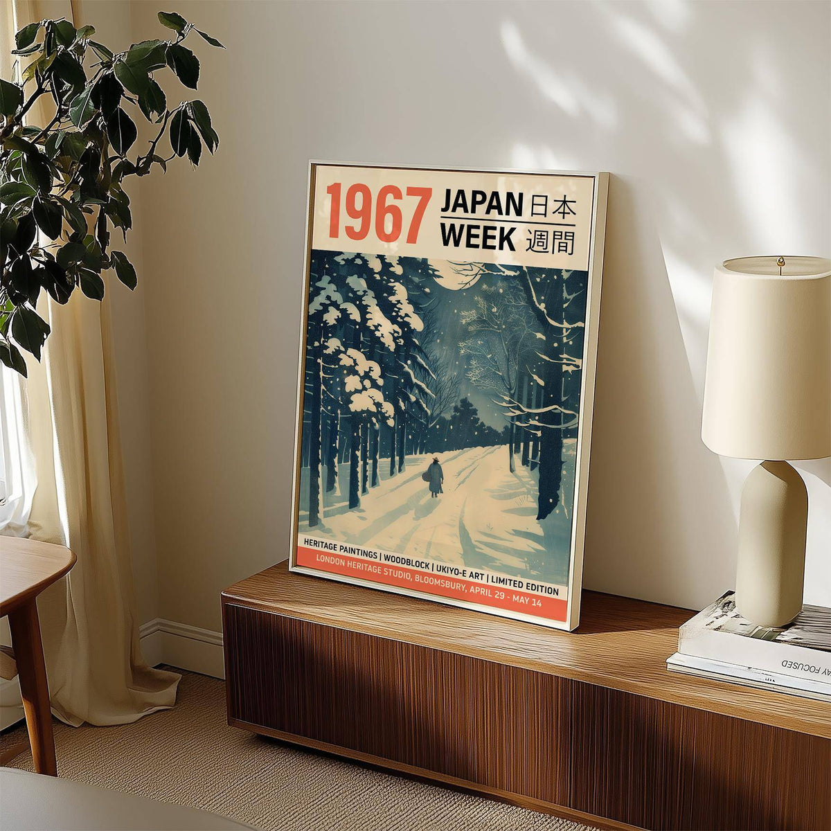Japanese Textile Prints in a frame showing a snowy forest path with dark blue trees on a wooden surface next to a lamp