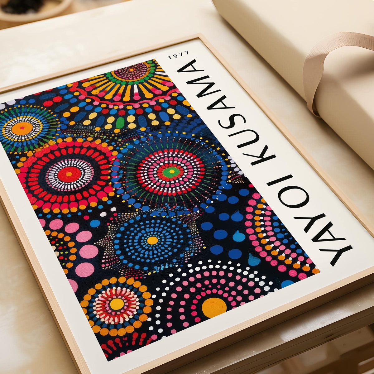 Framed Mandala Art for Wall with colourful circular patterns in red blue and yellow on a table next to gift wrapping