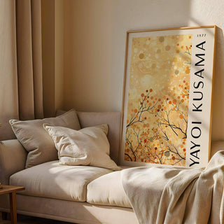 Print leaning on a sofa of yellow nature art with autumn branches and dots in warm tones