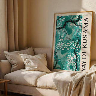 Teal wall decor leaning on a sofa in soft natural light with beige cushions and curtains