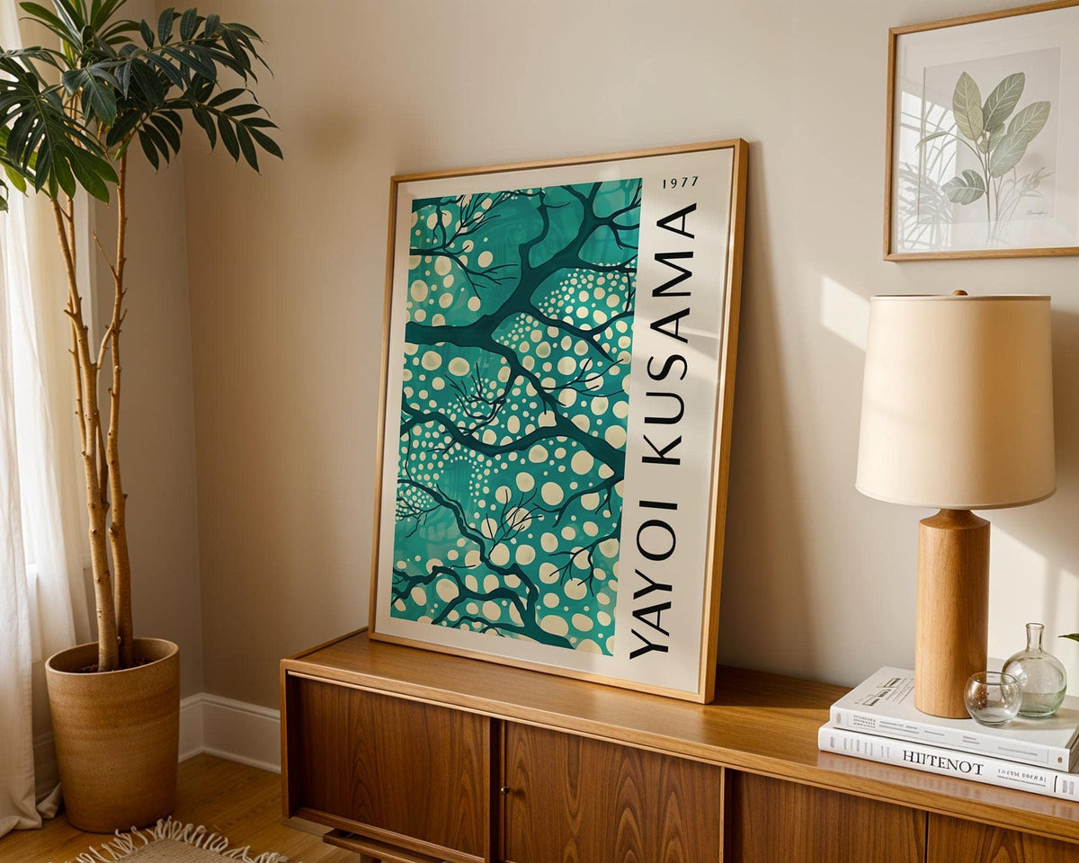 Teal wall art for living room leaning on a wooden sideboard with a lamp and plant beside it