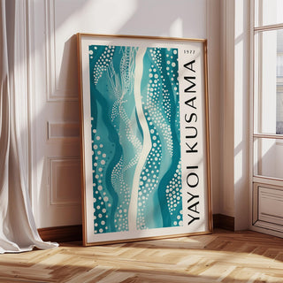 Abstract picture print with teal wavy shapes and dots leaning on a wooden floor by a window