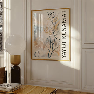 Large neutral wall art of delicate branches with berries and abstract shapes in a living room with a lamp and table