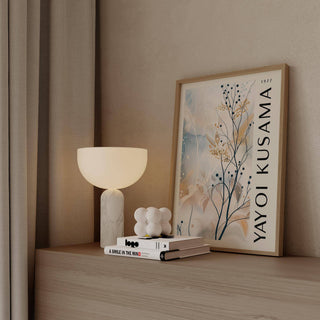 Large Neutral Wall Art framed print leaning on a surface with a white lamp and books nearby