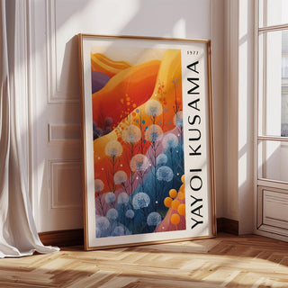 Print leaning on a wooden floor with sunlight blue orange wall decor of abstract flowers in warm tones by a window