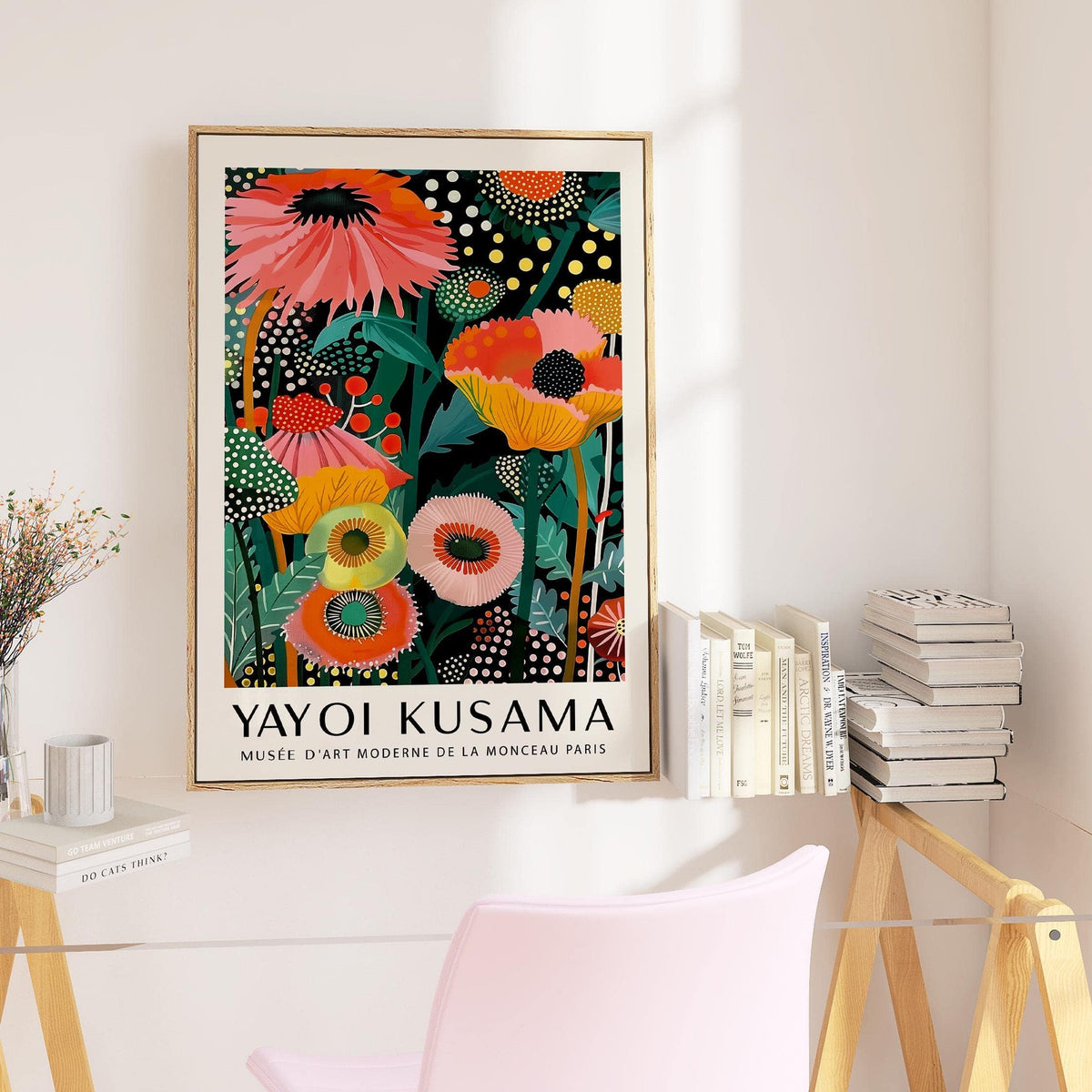 Tropical wall art of colourful stylised flowers in a bright room with books on a shelf
