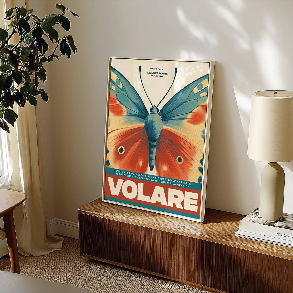Framed print of a vintage butterfly wall art with blue and orange wings leaning on a wooden sideboard with a white lamp