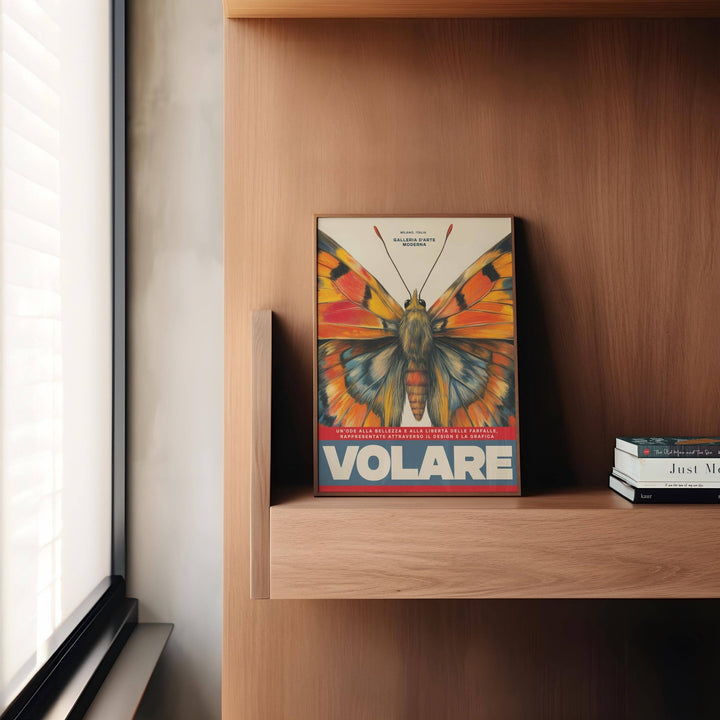 Print leaning on a wooden shelf with butterfly art wall showing radiant wings in orange and blue beside books