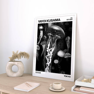 Jellyfish art print leaning on a desk with a circular vase and dried flowers