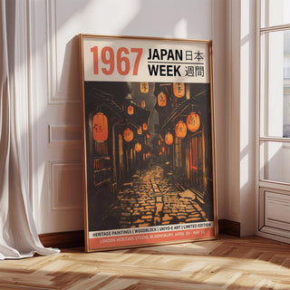 Framed Oriental Asian wall art of a lantern-lit alley in orange and brown leaning on a wooden floor near a bright window