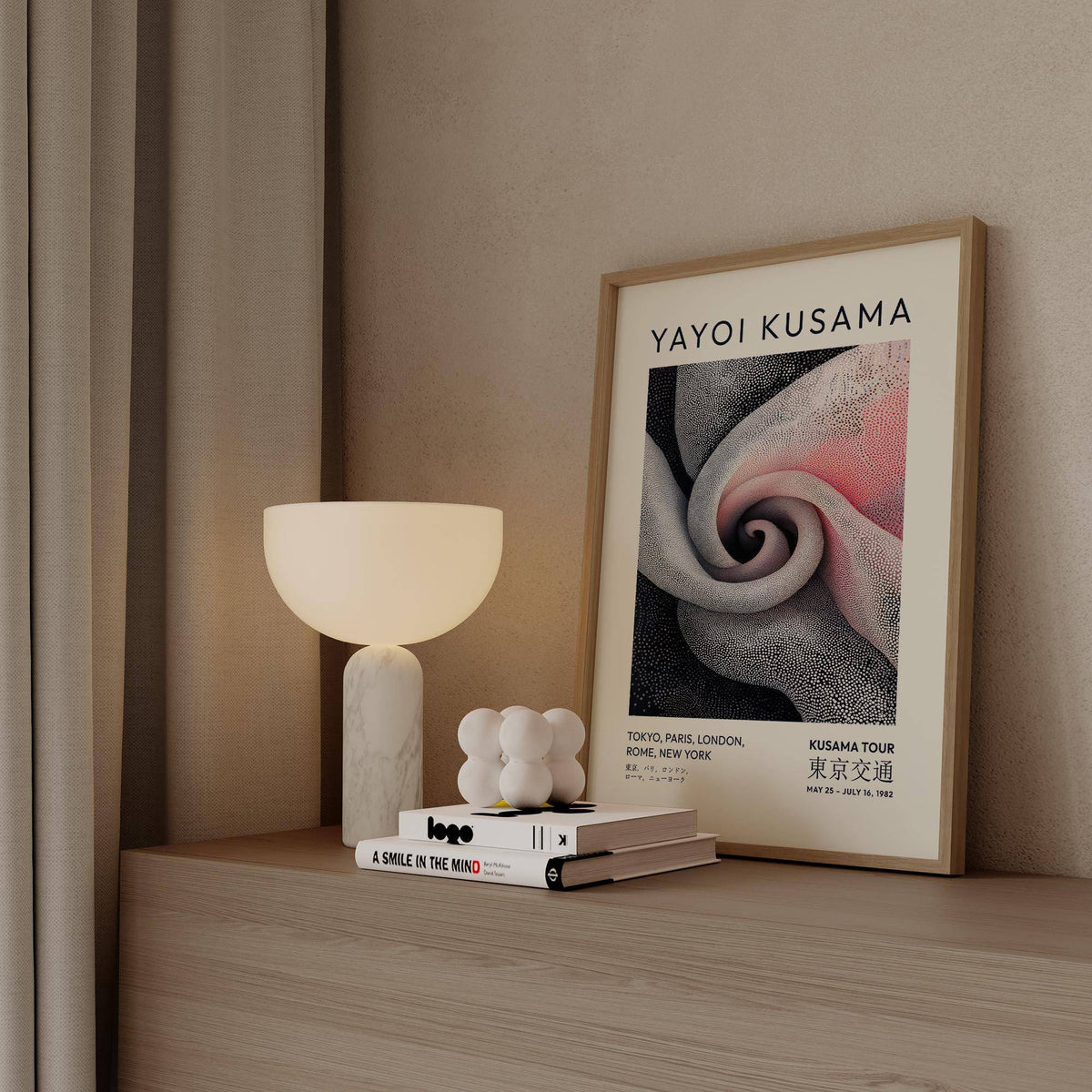 Framed print of spiral dot pattern in black white and pink with lamp on wooden surface