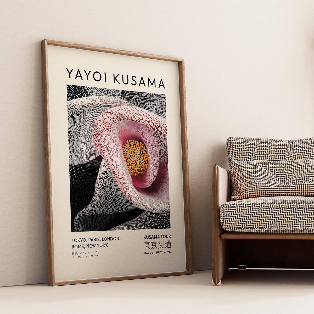 Pink abstract artwork leaning against a beige wall near a houndstooth armchair in a living room