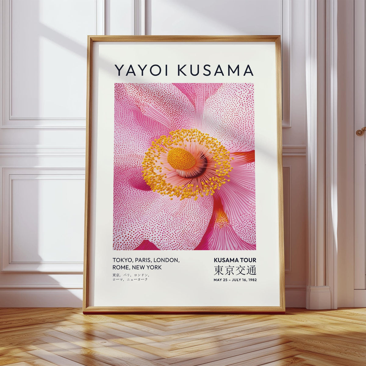 Framed print of pink blossom flower illustration with a golden frame leaning on a wooden floor