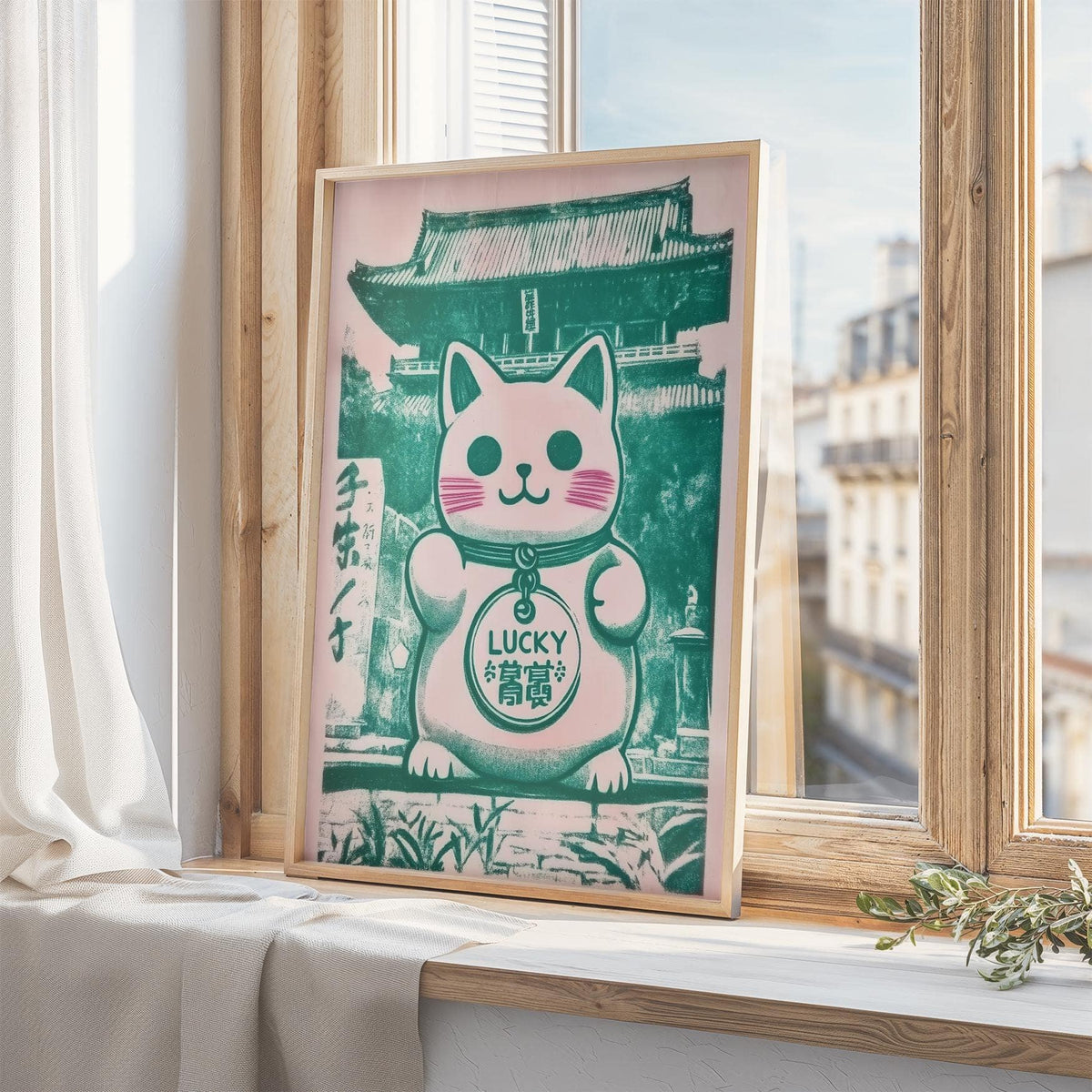 Framed Good Luck Presents print of a pink and green maneki-neko cat figurine on a windowsill