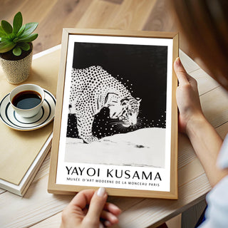 Framed white tiger wall art in black and white held over a wooden table with a cup of coffee
