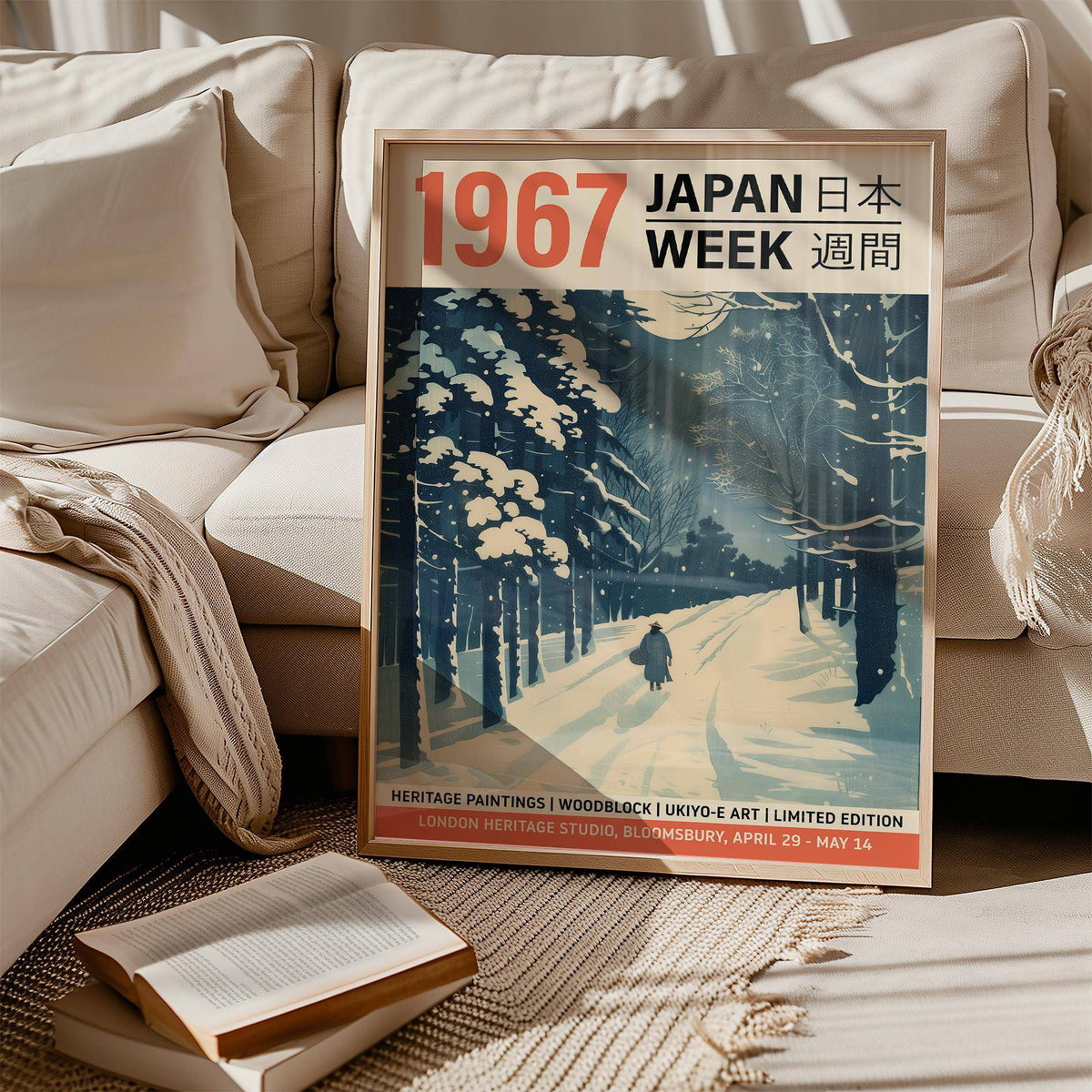 Framed print close-up of a snowy forest path in blue and white sitting on sofa with a book nearby
