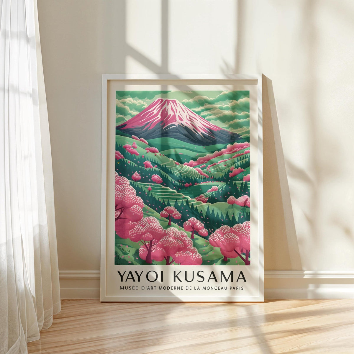 Mountain Landscape print leaning on a wooden floor with pink cherry blossom and green mountains in soft light