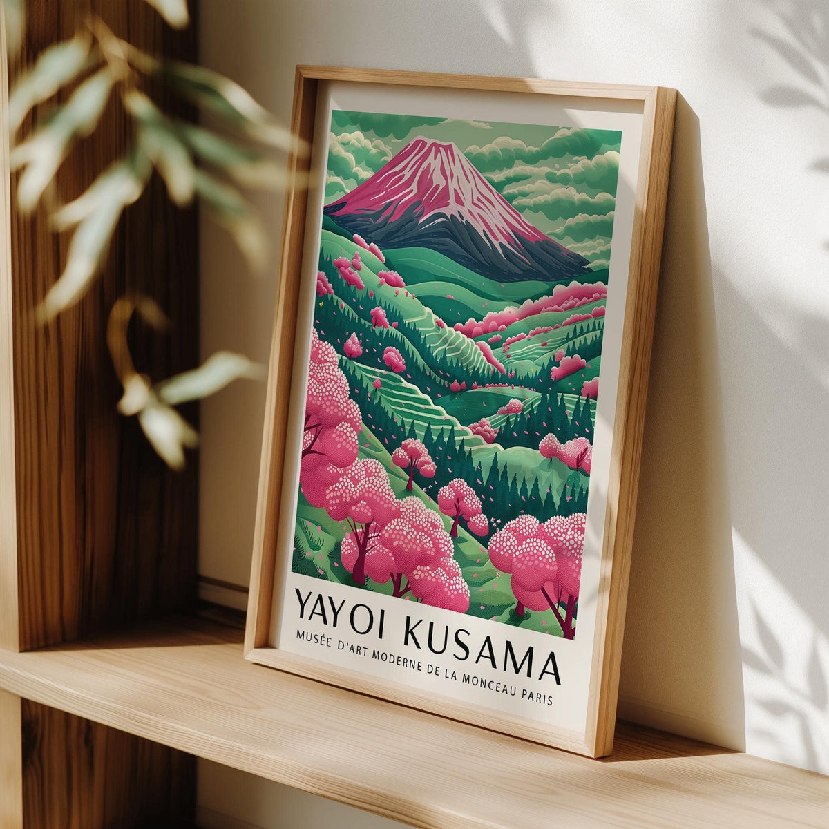 Mountain Landscape framed print with pink cherry blossom trees leaning on a wooden shelf with sunlight