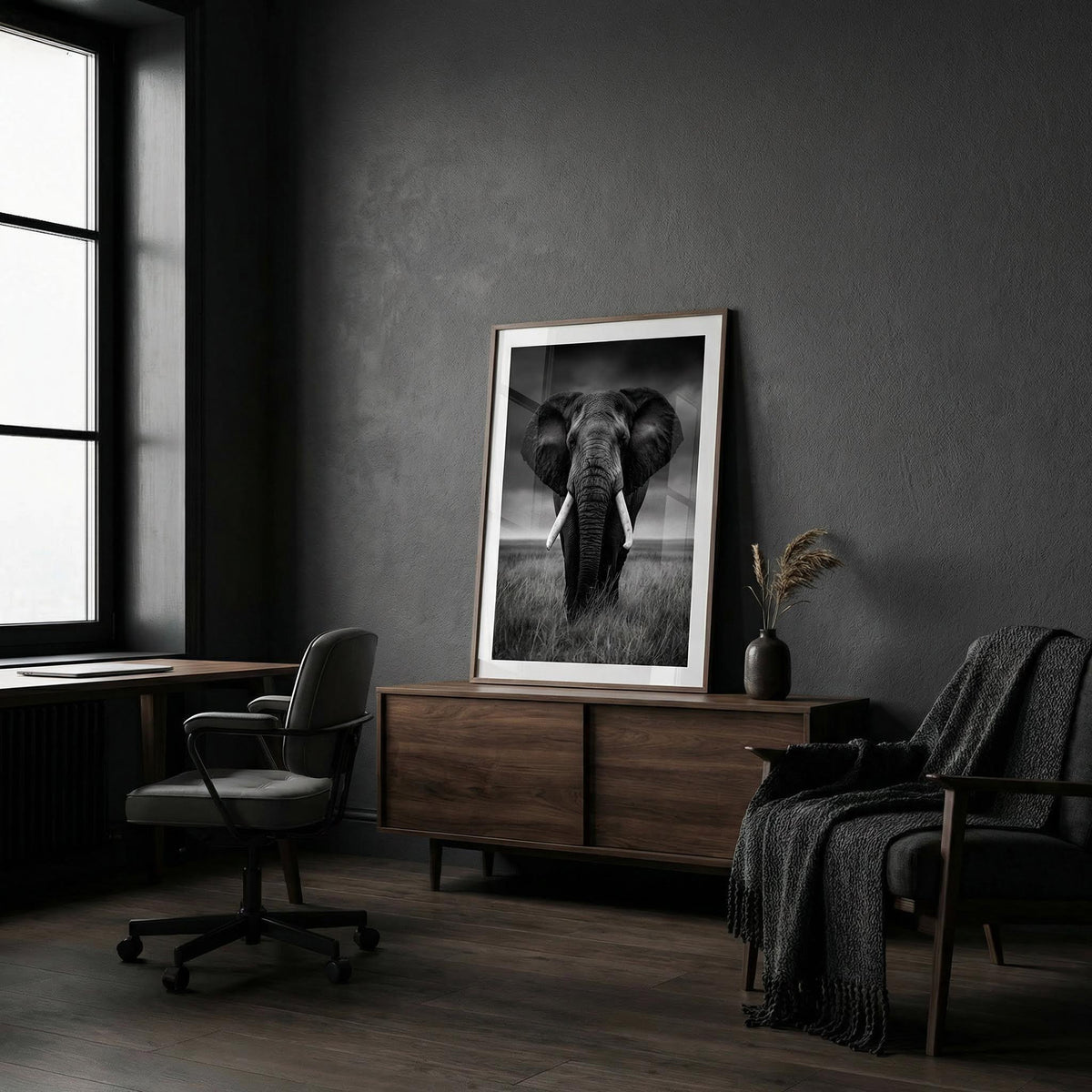 Black And White Elephant Print leaning on a wooden sideboard with a vase in a dark room