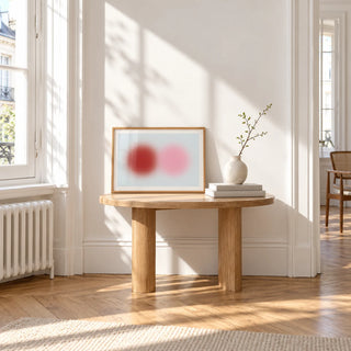 Red and Pink Circles Print, a small A4 framed print leaning on a small solid oak side table