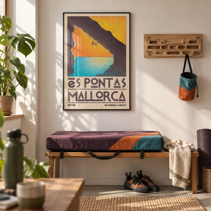 Mallorca Climbing Poster, framed on the wall of a home training room with a white wall and a small wooden hangboard