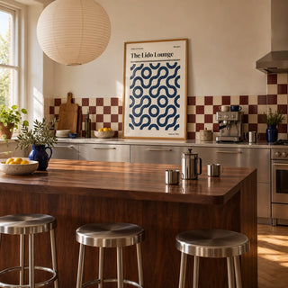 Margate Print, framed on the wall of a warm kitchen with a burgundy and cream checkerboard tile splashback and brushed steel cabinets