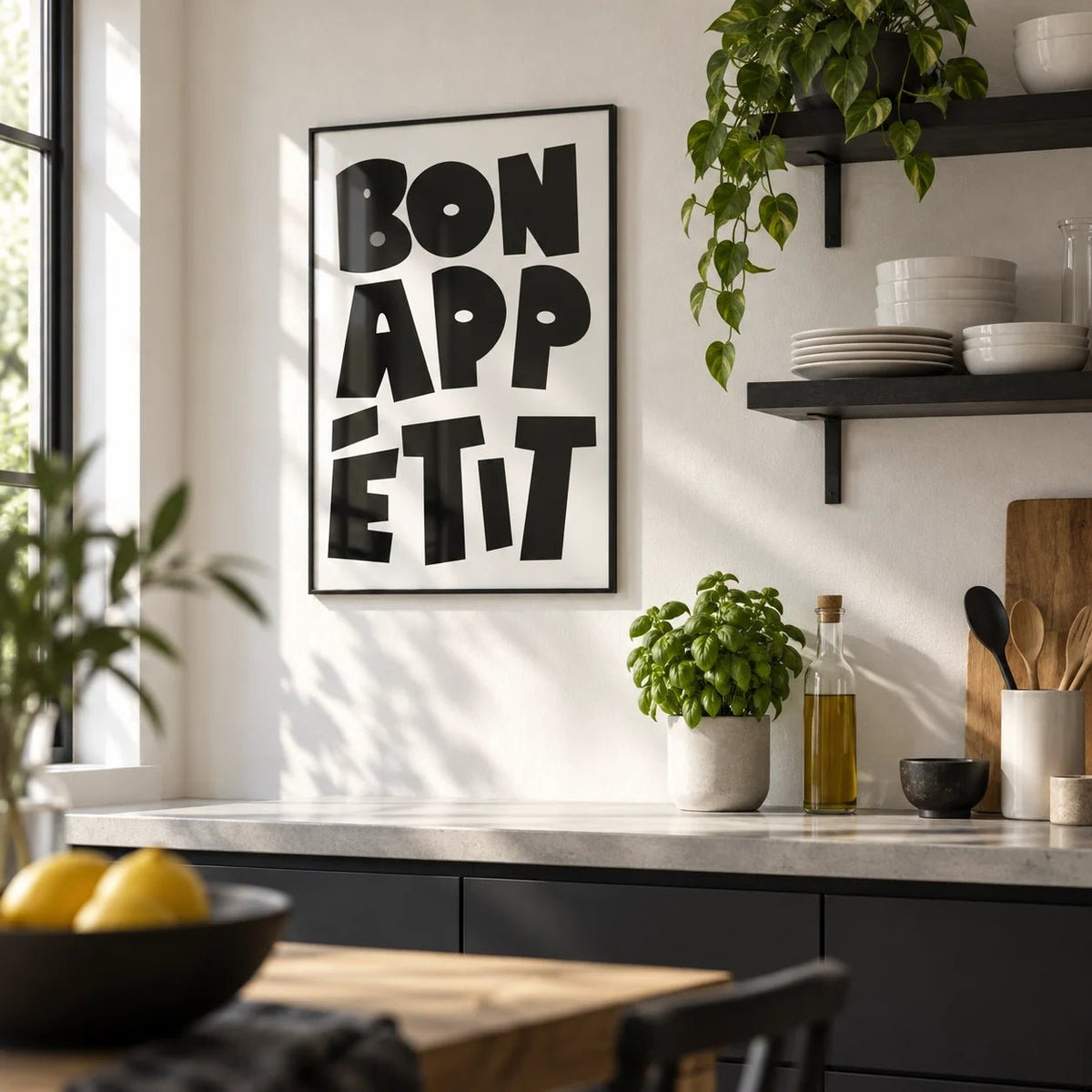 French Art Prints, framed on the wall of a modern kitchen with a plain white plaster wall and black open shelving