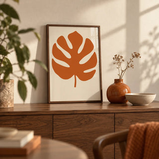 Monstera Print, a small A4 framed print leaning on a walnut side table in a hallway