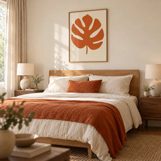 Monstera Print, framed on the wall of a warm modern bedroom with a pale cream wall and simple walnut bedside tables