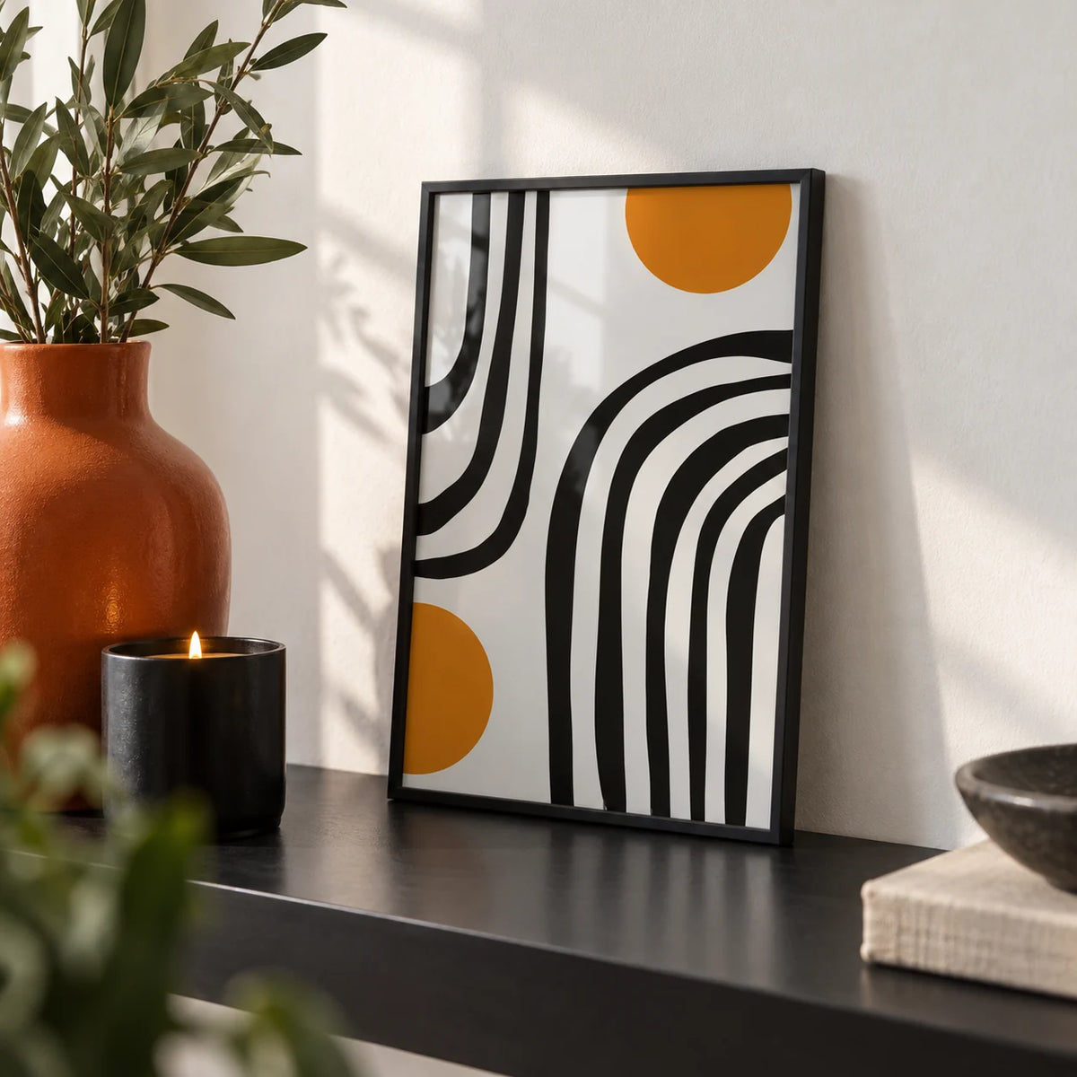 Orange and Black Wall Art, a small A4 framed print leaning on a black shelf in a living room