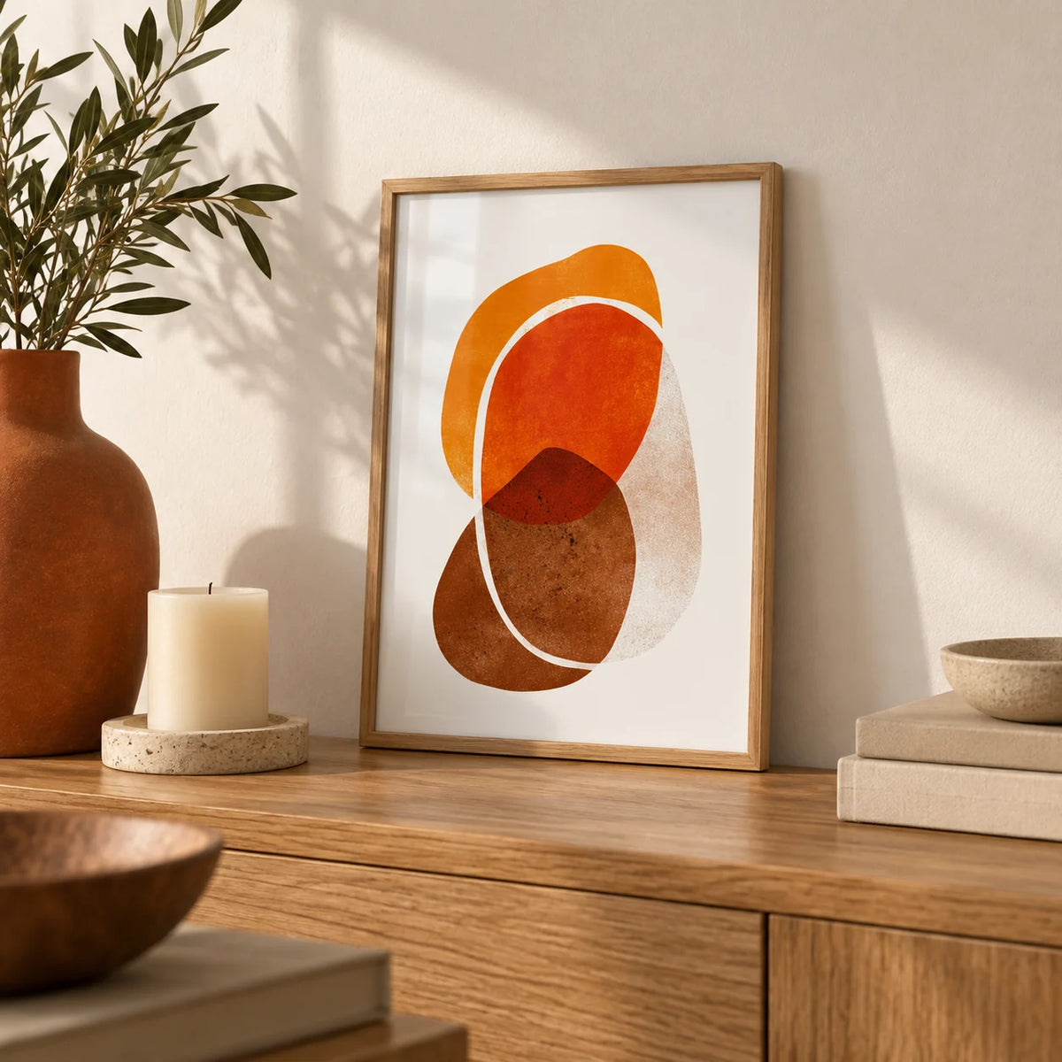 Orange Shapes Art Print, a small A4 framed print leaning on an oak sideboard in a living room