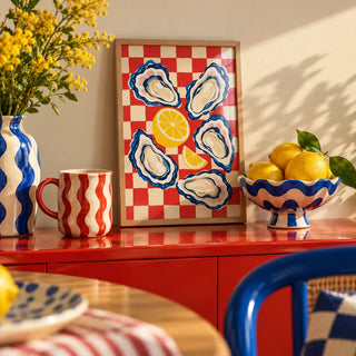 Oyster Print, a small A4 framed print leaning on a colourful lacquered shelf in a living room