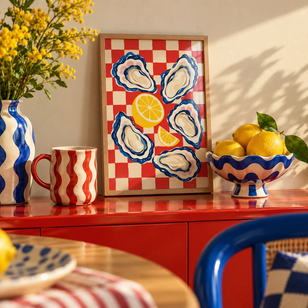 Oyster Print, a small A4 framed print leaning on a colourful lacquered shelf in a living room