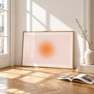 Peach Aura Print, framed and leaning on the parquet floor of a bright living room