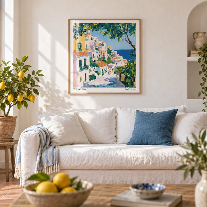 Positano Art, framed on the wall of a bright Amalfi-style living room with smooth white plaster walls and a plain terracotta floor