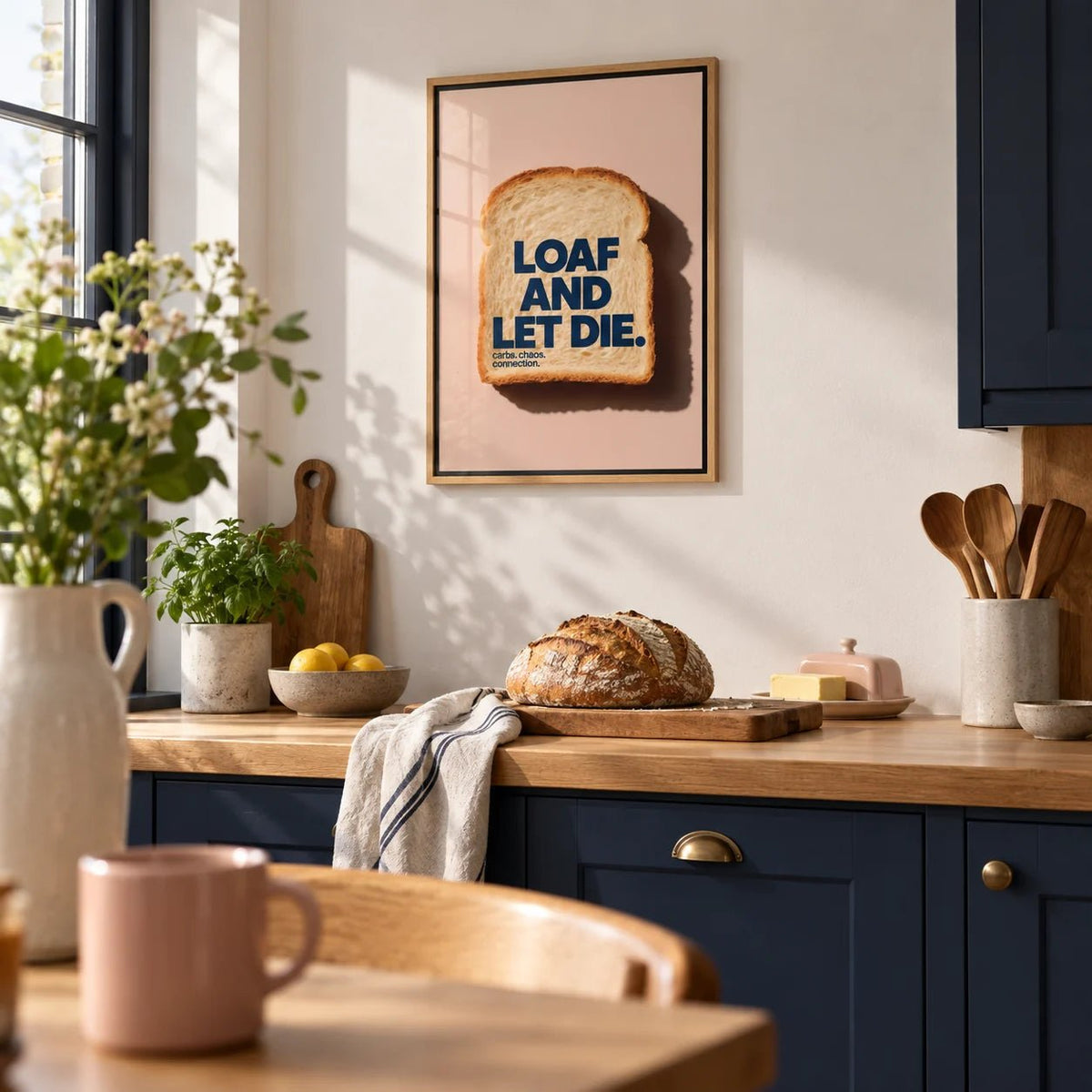 Quirky Kitchen Art, framed on the wall of a modern kitchen with solid navy cabinets and an oak worktop