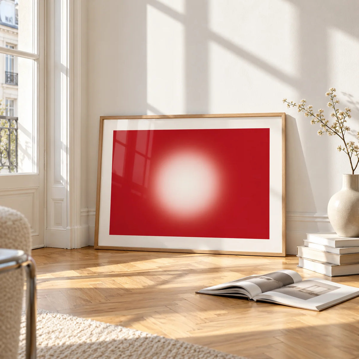 Red Abstract Wall Art, framed and leaning on the parquet floor of a bright living room
