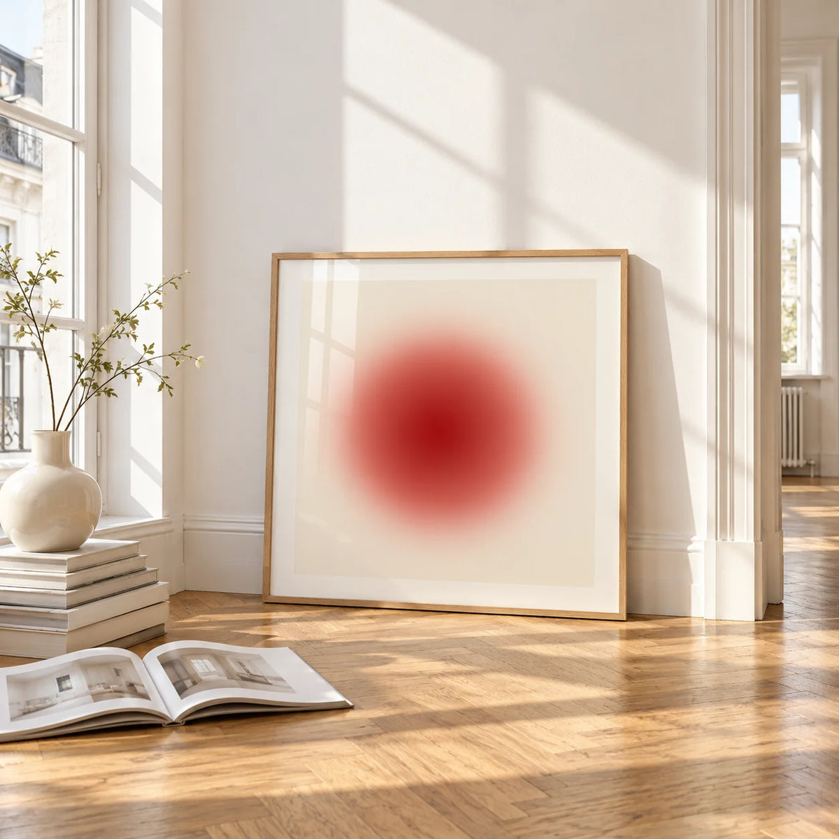 Red Circle Wall Art, framed and leaning on the parquet floor of a bright living room