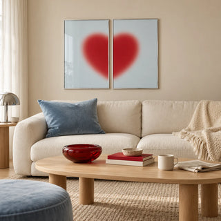 Red heart print set of 2 hung above a cream sofa in a living room