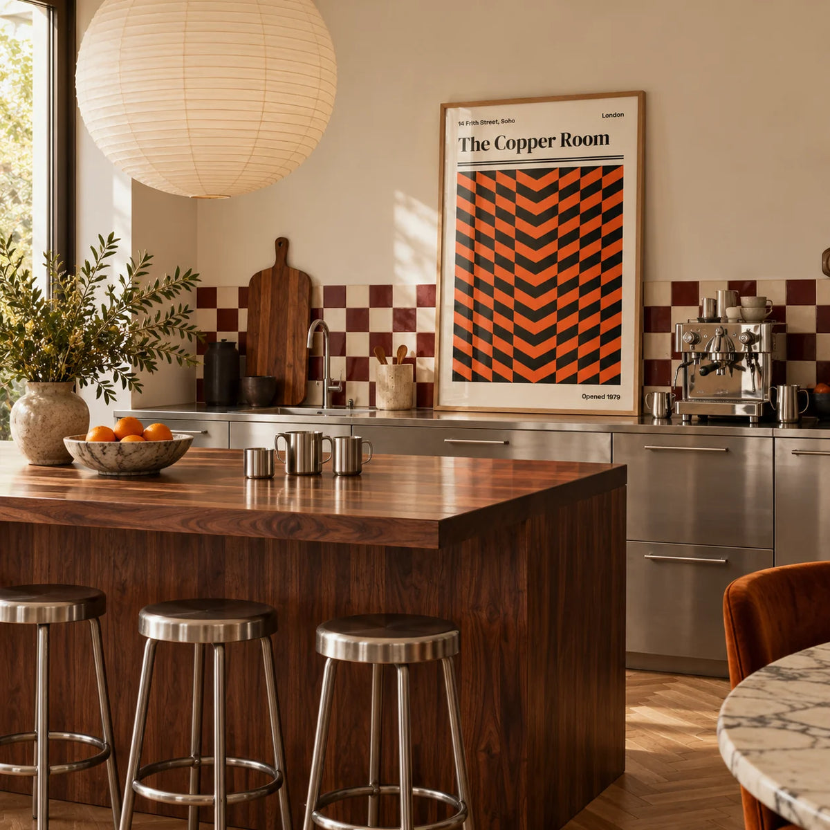 Retro London Poster, framed on the wall of a warm kitchen with a burgundy and cream checkerboard tile splashback and brushed steel cabinets