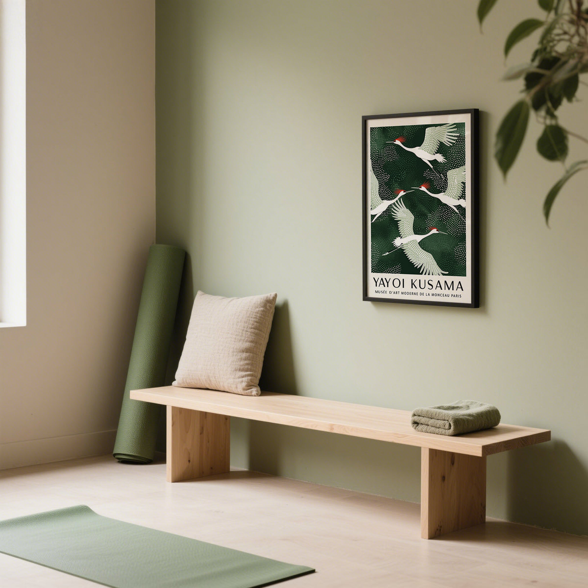 Japandi wall art of red-crowned cranes flying with a dark green background on an olive wall near a yoga mat