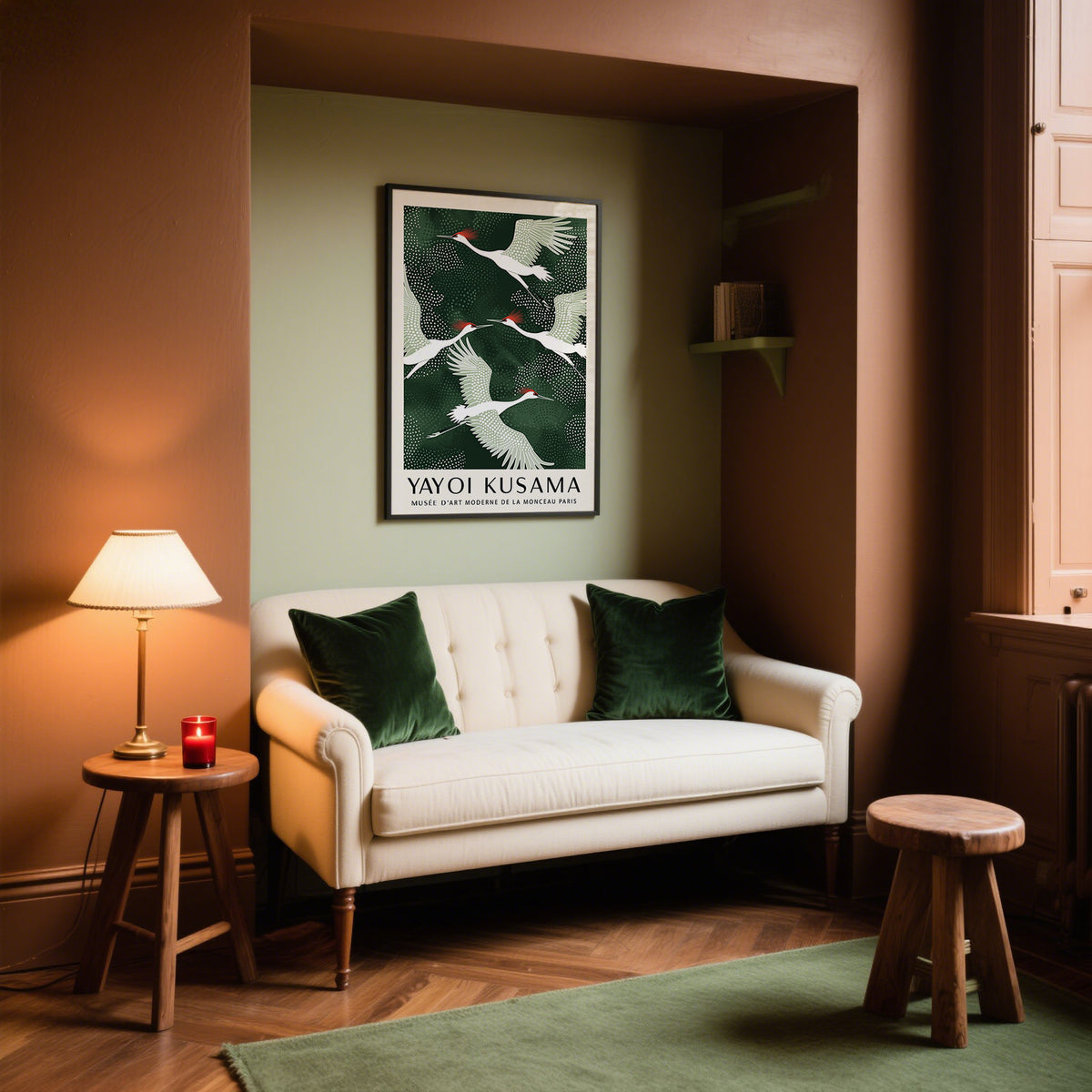 Japandi wall art of flying red-crowned cranes with dark green and white tones above a white sofa with green cushions