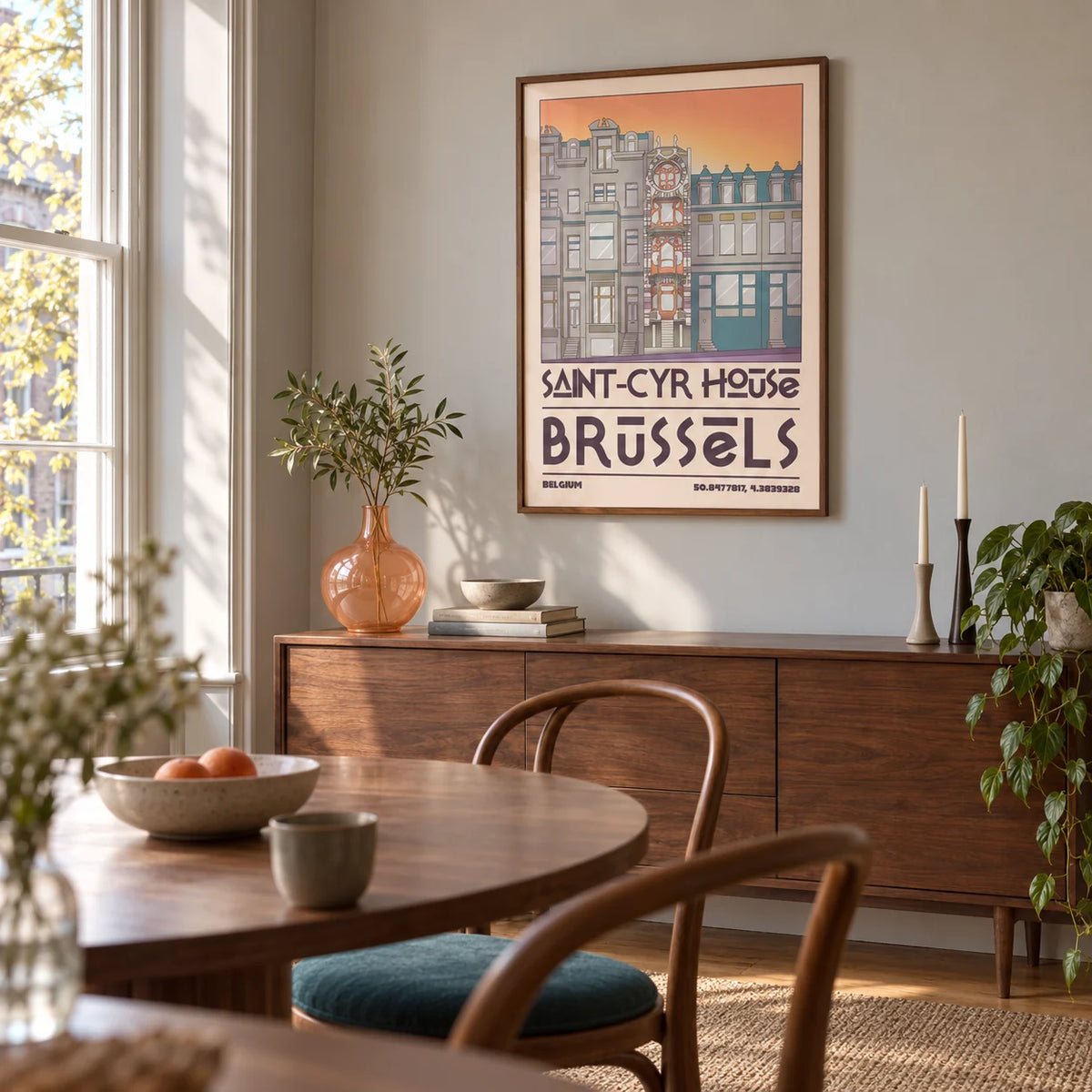 Saint Cyr House Poster, framed on the wall of a compact dining room in a design-conscious UK flat with warm grey walls and a tall sash window